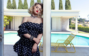 Bright singer Selena Gomez in a dress by the pool