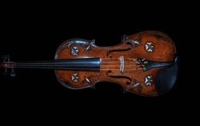 Large wooden violin on a black background