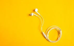 Белые наушники на желтом фоне