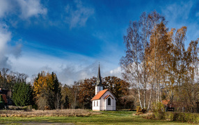 Old chapel in a park under a beautiful blue sky