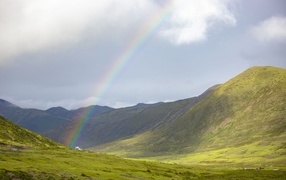 Радуга над покрытыми зеленью холмами