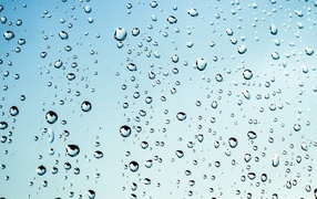 Капли дождя на голубом стекле