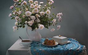 Букет белых хризантем стоит на столе с чаем