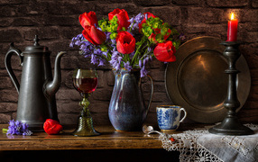 Букет цветов на столе со свечой и вином