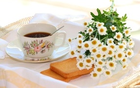 Букет белых ромашек с чашкой чая  и хлебом