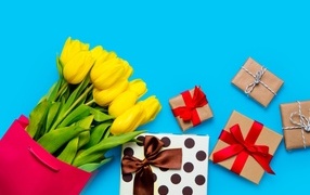 Букет желтых тюльпанов с подарками на голубом фоне
