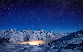 Beautiful night sky over snow covered mountains