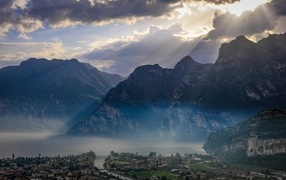 Лучи солнца покрывают горы и город 