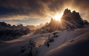 Солнце пробивается сквозь вершину горы