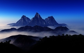 Three mountain peaks in the fog
