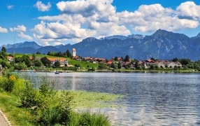 Красивый вид на озеро и горы под голубым небом с белыми облаками