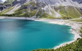 Чистая голубая вода в озере у высоких гор 