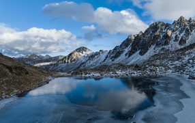 Cold frost covers the water of a mountain lake with ice