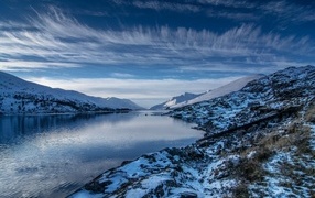 Lake with snow covered mountains under beautiful sky