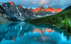 Горы и небо отражаются в голубой глади озера