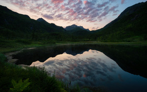 The evening sky is reflected in a mountain lake