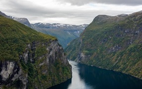 Река протекает между высоких гор 