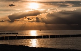 Bright sun behind the clouds over the sea
