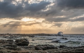 Лучи солнца пробиваются сквозь тучи над морем