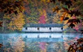 The house is reflected in the lake in autumn