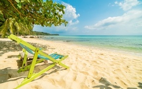 Шезлонг стоит на берегу моря летом