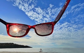 Sunglasses on the background of the sky in summer