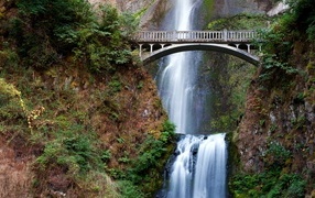 Bridge between mountains over a waterfall