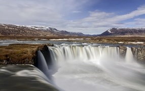 Водопад стекает вниз на фоне гор