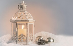 Зажженный фонарь с игрушками стоит на снегу