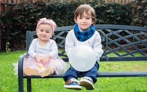 Boy and girl sitting on a park bench