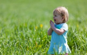 Cheerful girl on a field with green grass