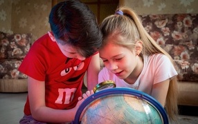 Дети школьники изучают глобус