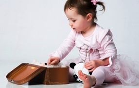 Девочка в розовом наряде с маленьким чемоданом