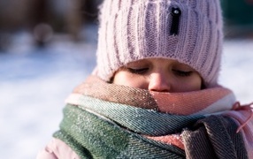 Девочка в теплой вязаной шапке зимой
