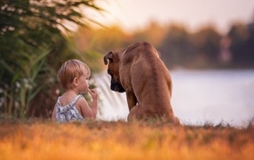 Девочка с собакой на берегу реки