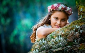 Девочка с венком на голове в саду