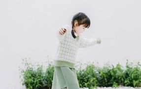 Маленькая девочка азиатка в теплом костюме