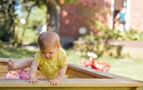 Маленький мальчик играет в песочнице