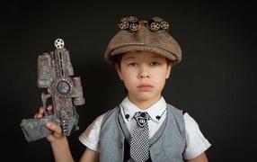 Little boy with a toy gun on a black background