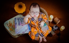 Маленький спящий ребенок в очках и халате