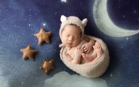 Маленький спящий грудной ребенок на синем покрывале