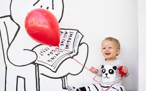 Маленький улыбающийся мальчик с шариком в руках