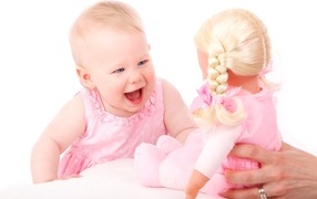 Маленькая улыбающаяся девочка с куклой