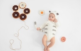 Newborn baby in a suit with donuts
