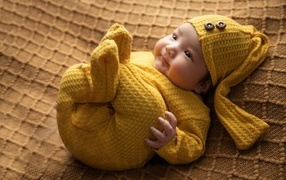 Новорожденный ребенок в желтом костюме 