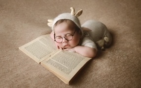 Новорожденный ребенок спит с книгой