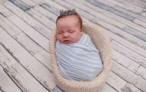 Новорожденный ребенок с короной на голове