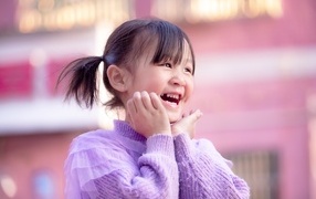 Улыбающаяся маленькая девочка азиатка в свитере