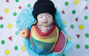 Улыбающийся ребенок в черной вязаной шапке 