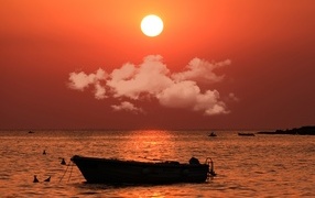 Старая лодка в воде на закате солнца